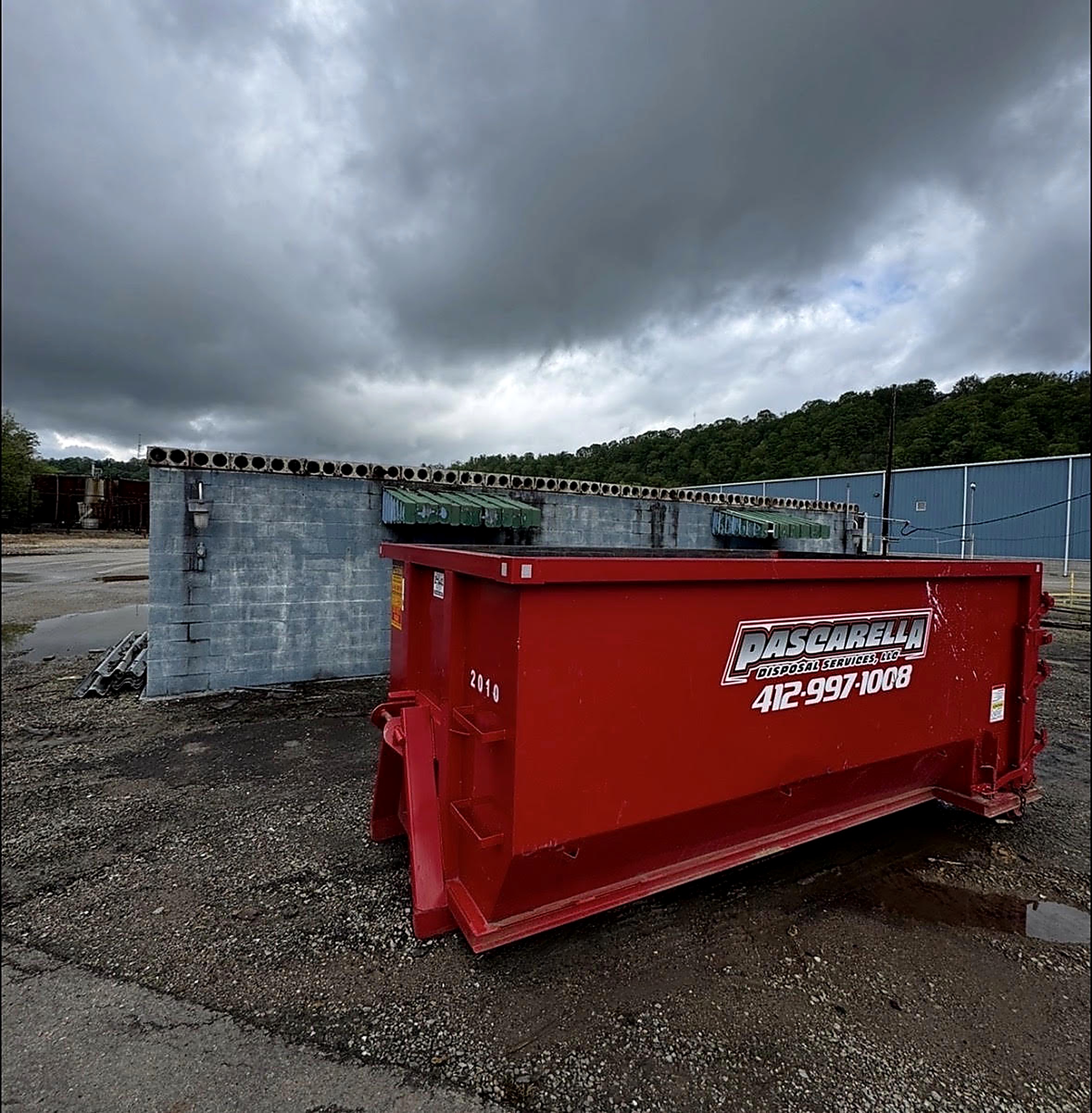 Pascarella Disposal red roll-off dumpster delivered on a Pittsburgh-area driveway