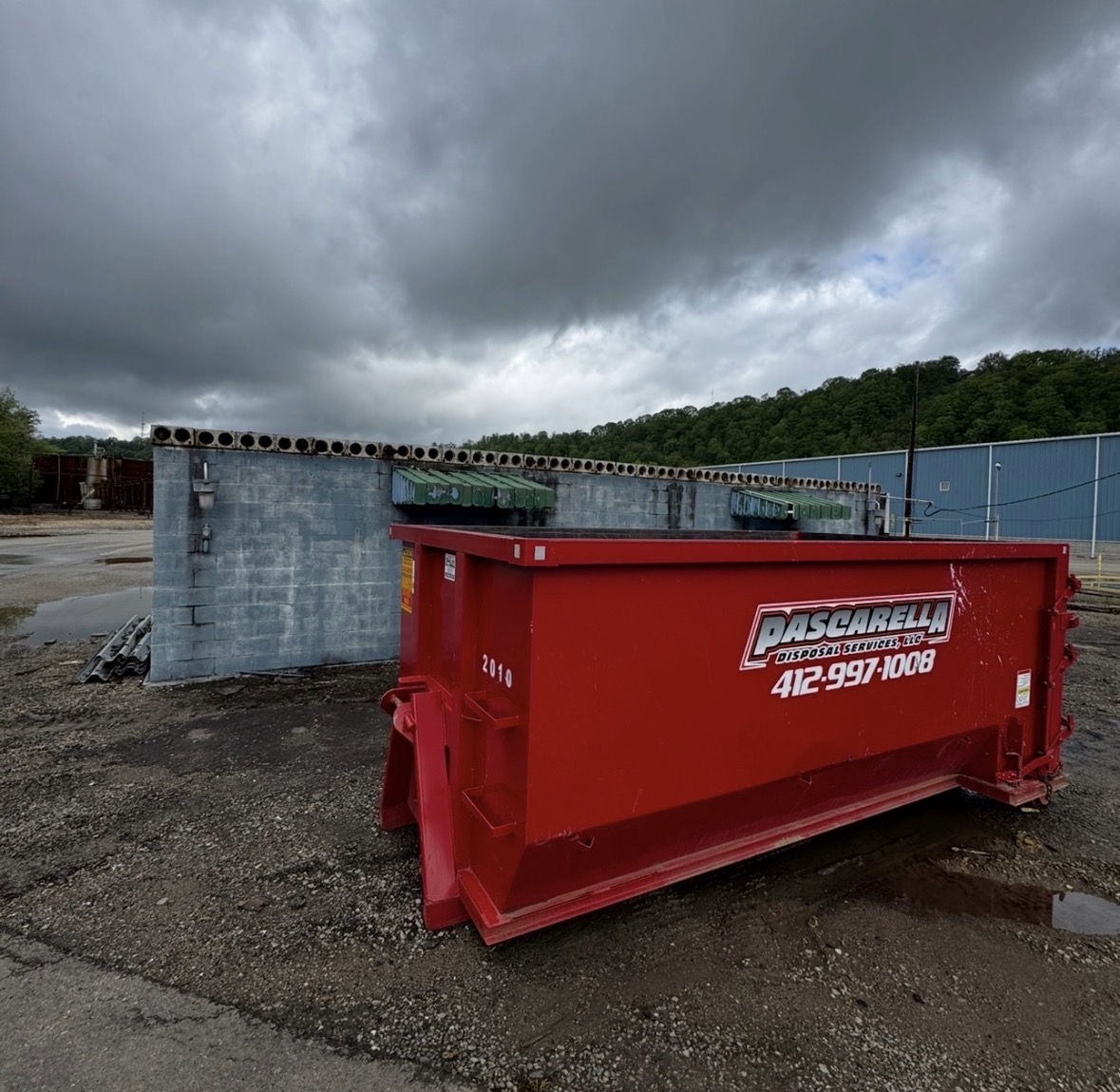Pascarella 20-yard dumpster at a commercial industrial site under stormy skies