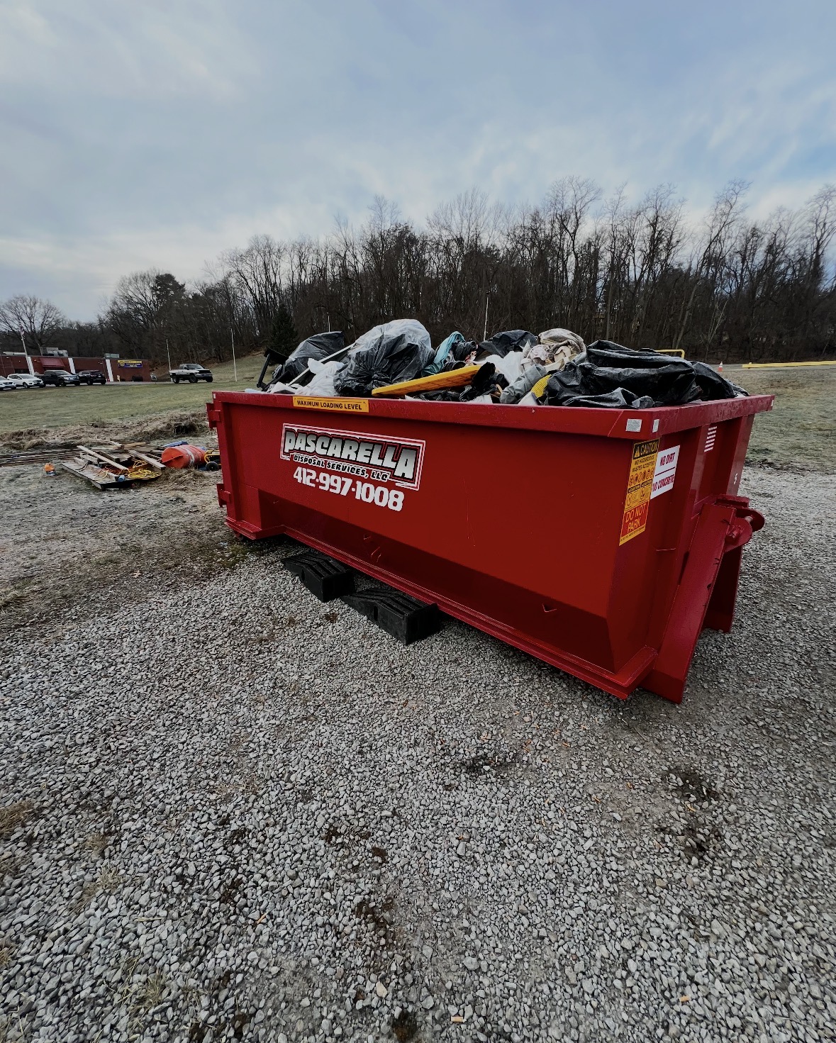 Full Pascarella dumpster on protective blocks at a Pittsburgh cleanout job