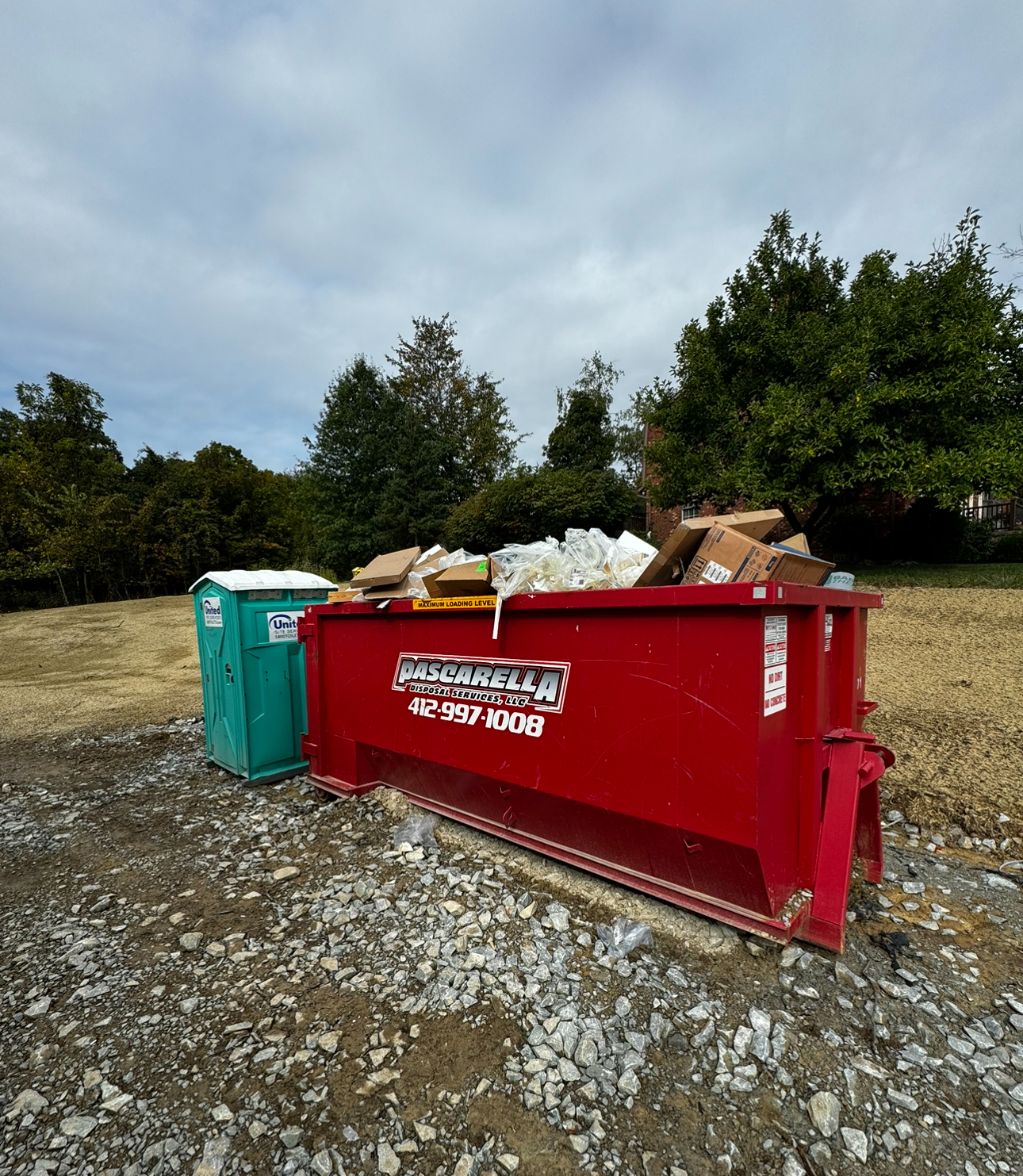 Pascarella dumpster and portable toilet on a new construction lot