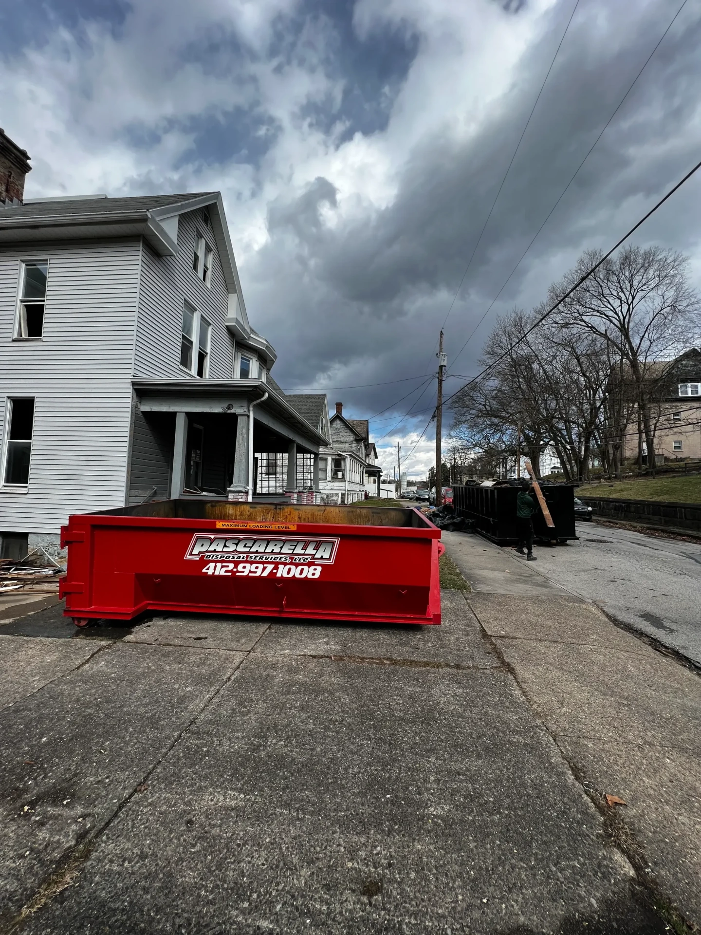 Pascarella dumpster on a city street during a multi-property cleanout