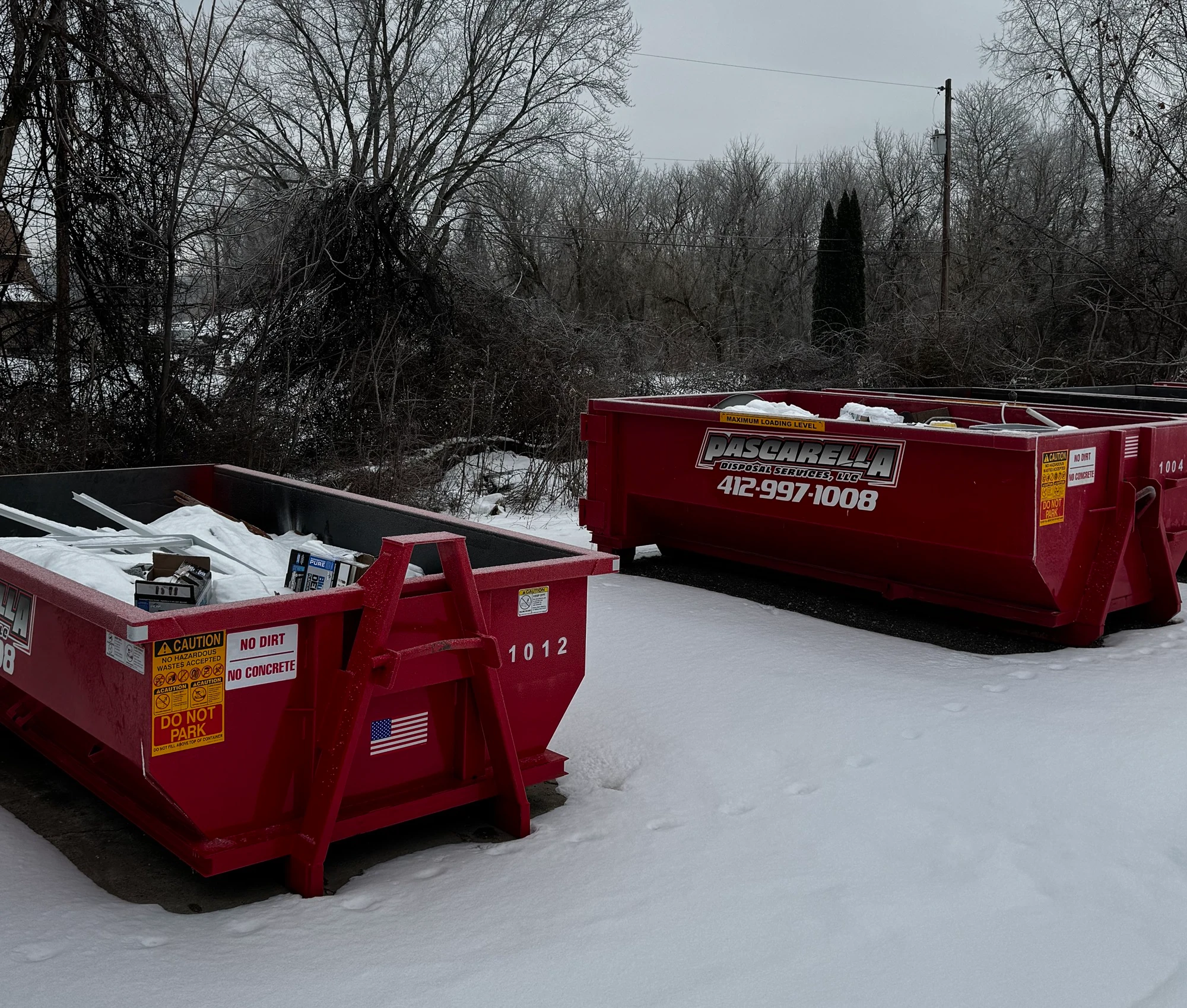 Two Pascarella roll-off dumpsters staged for a winter job