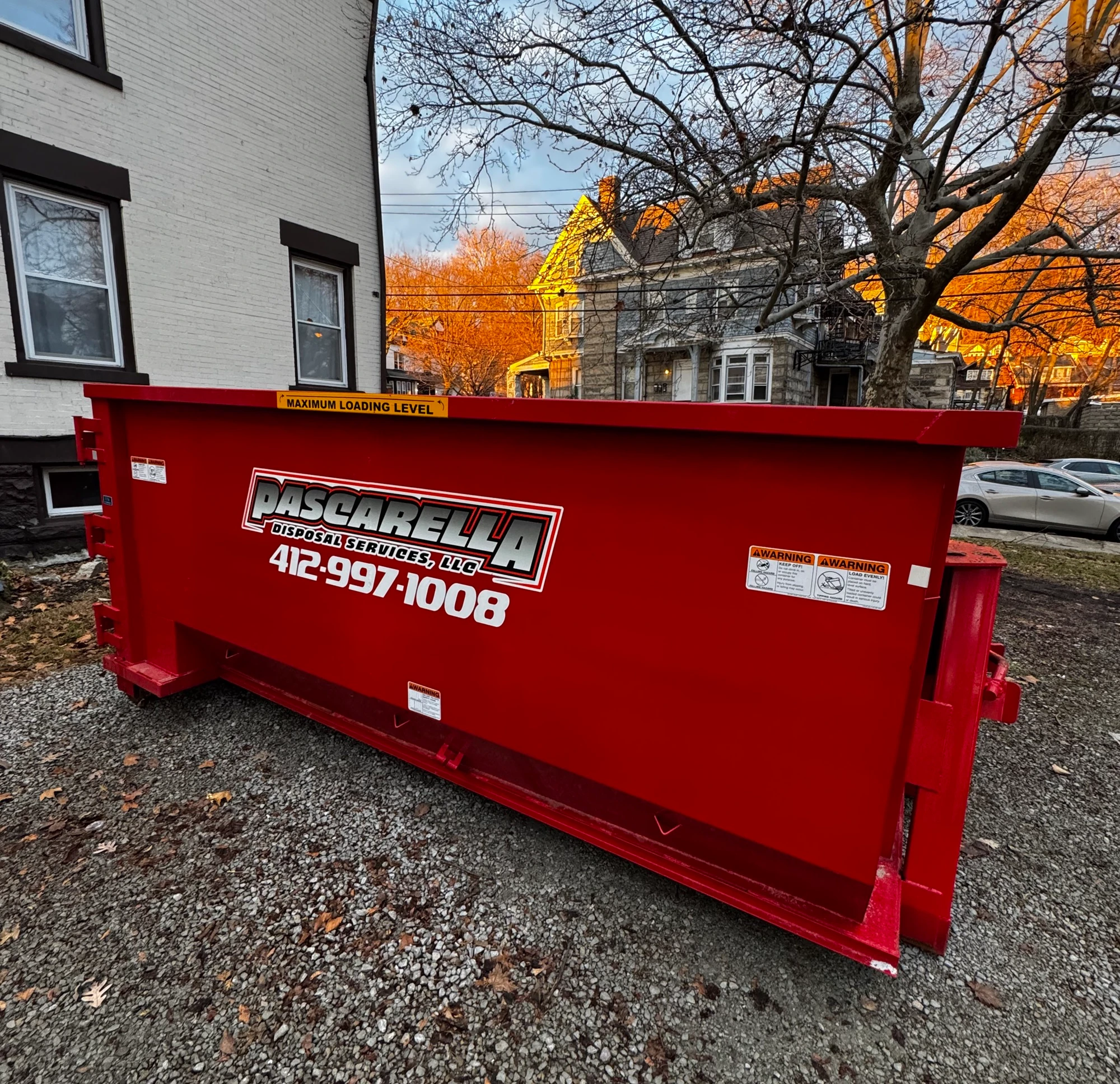 Pascarella dumpster on a tree-lined Pittsburgh street at golden hour